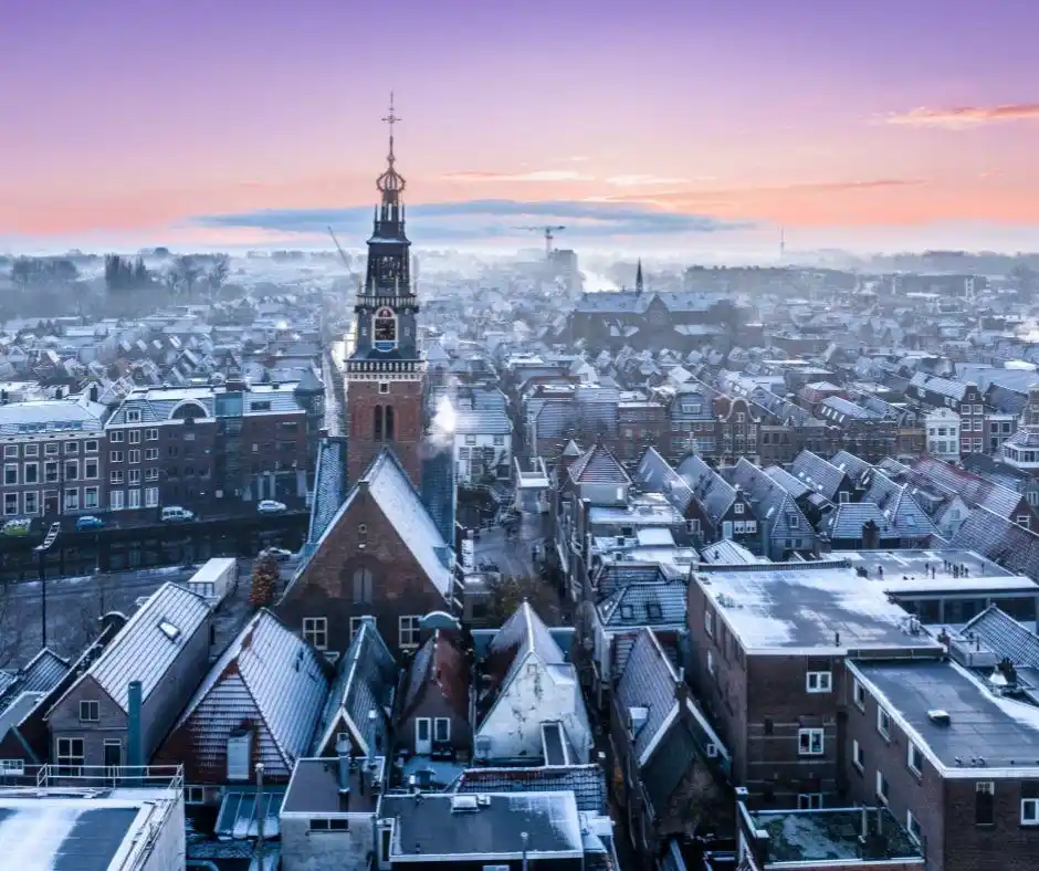Foto vanaf boven de stad met zonsopgang met roze,  paars en oranje kleuren over Alkmaar heen
